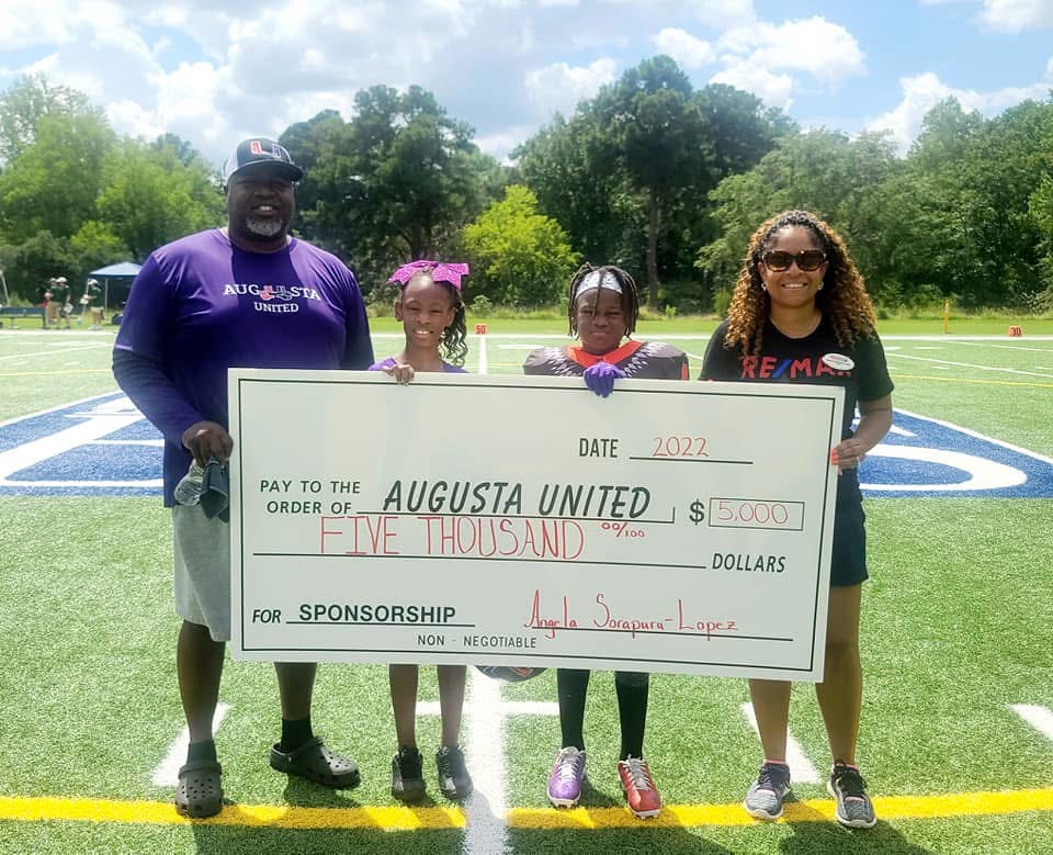Angela presenting a sponsorship check to Augusta United youth football