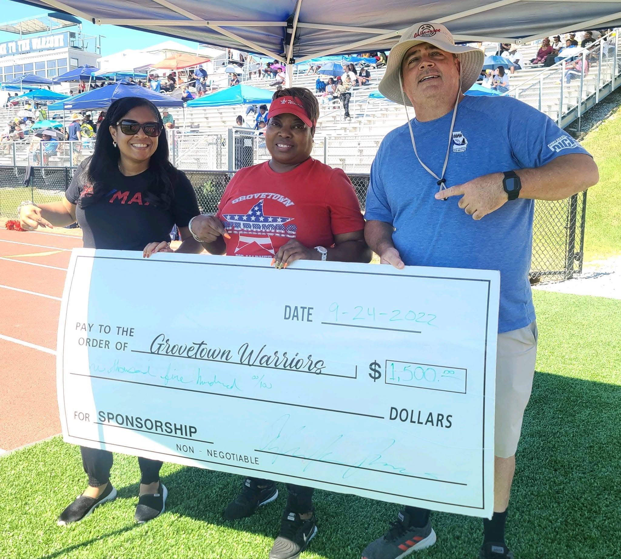 Angela presenting a sponsorship check to Grovetown Warriors